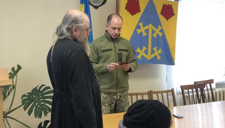 A priest of the UOC is given a medal of his fallen hero son. Photo: Zhytomyr Eparchy